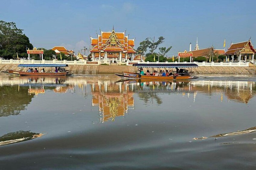 A temple with a reflection in the water, boats, and a clear sky. 3