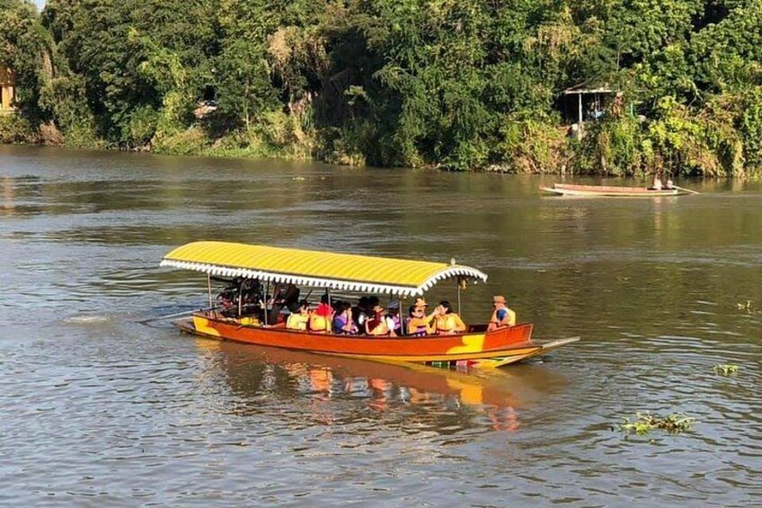 A boat with a yellow canopy on a river surrounded by greenery. 2
