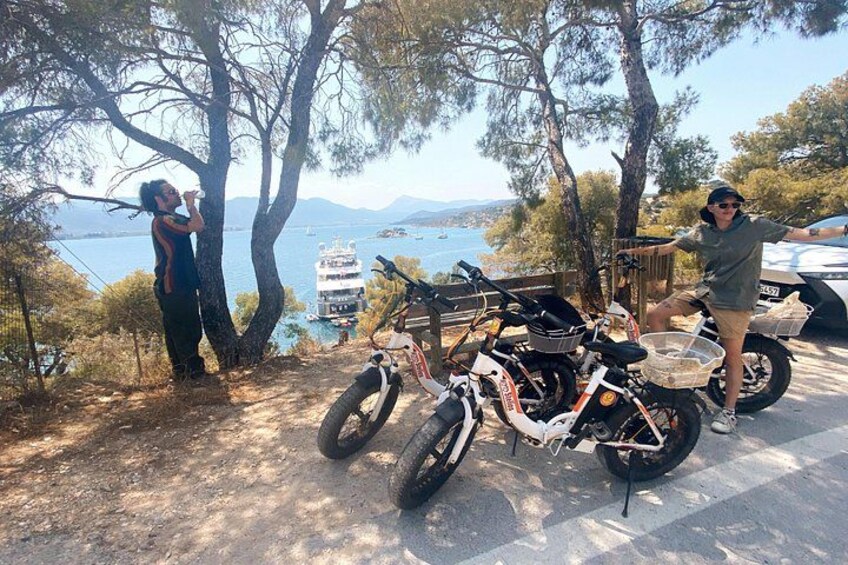A person drinking water, a motorcycle, and a boat on a lake. 5