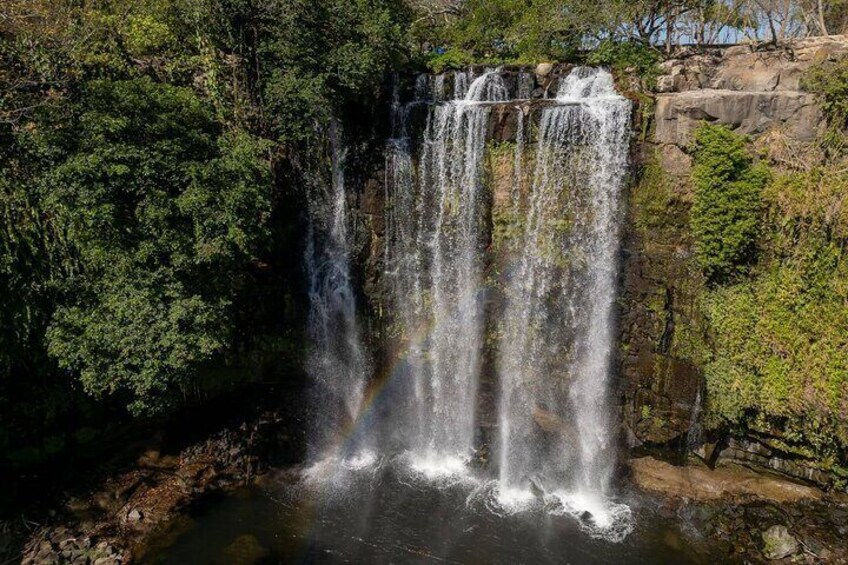 Une cascade d’eau se déversant sur des rochers, le tout étant entouré d’une végétation luxuriante. 3