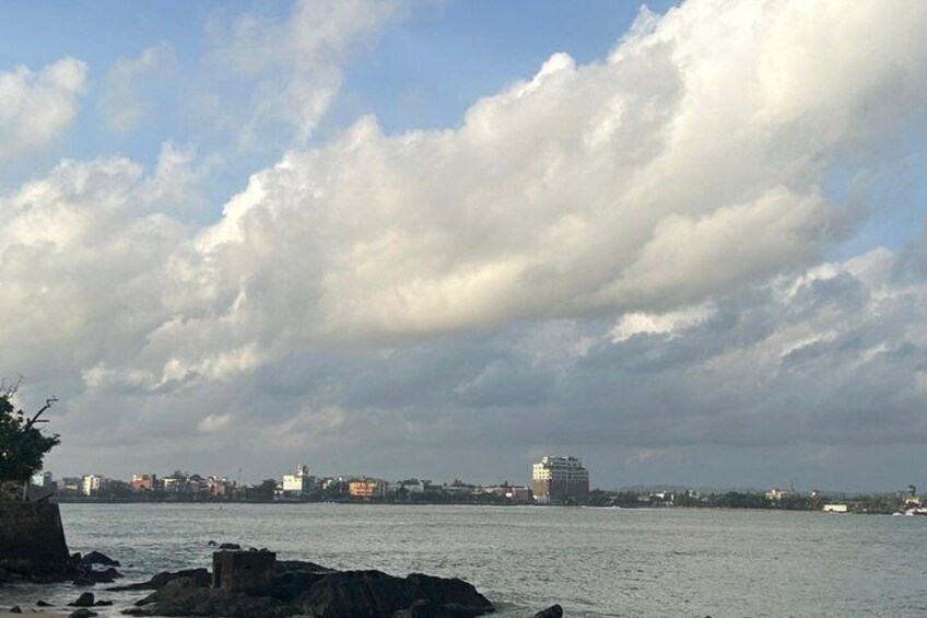 Eine Küstenstadt mit einem markanten weißen Gebäude, ruhiger See und bewölktem Himmel. 5
