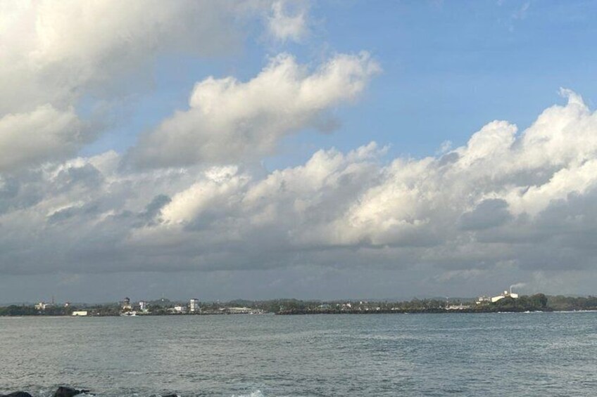 Ein Gewässer mit einer entfernten Uferlinie, bewölktem Himmel und vereinzelten Wolken. 3