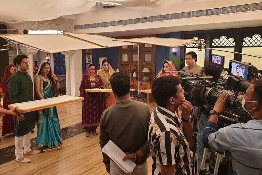 A group of people in a room with a camera crew filming. 1