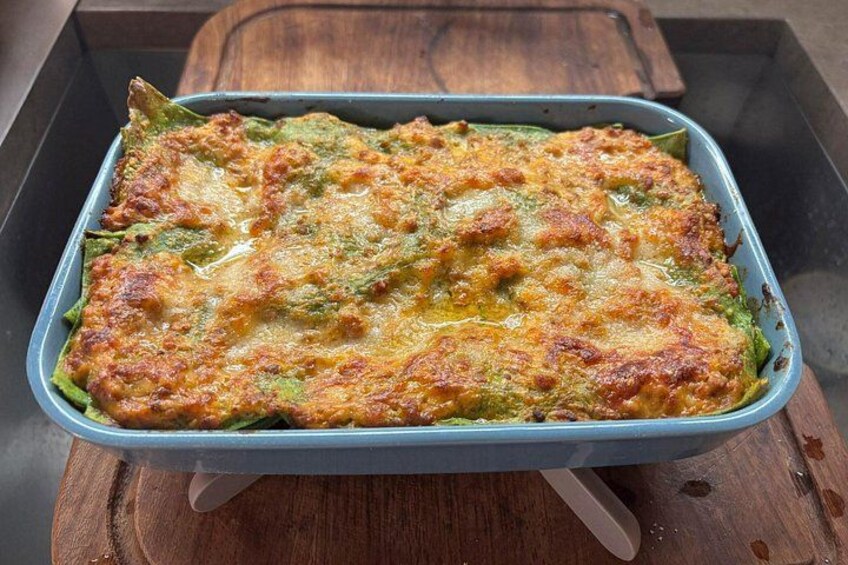 A baked dish in a blue baking dish on a wooden surface. 2
