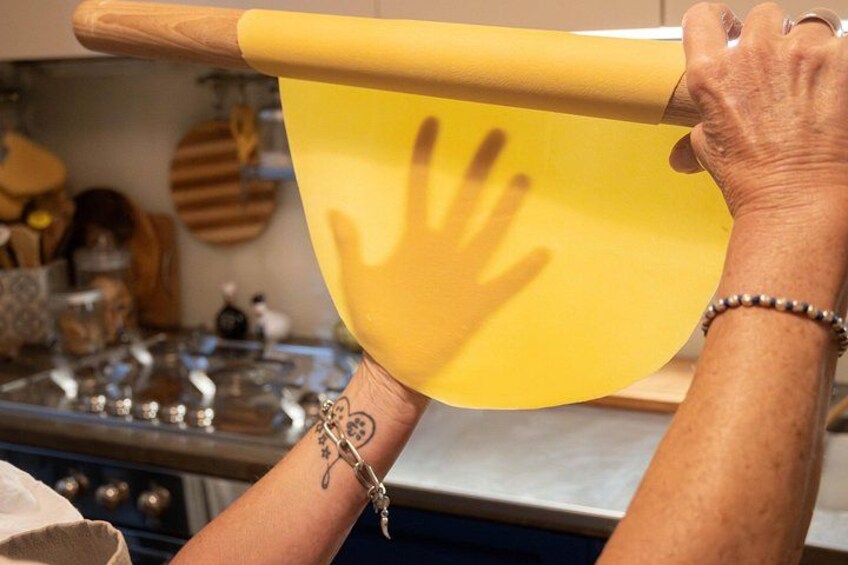 A person rolling dough with a wooden rolling pin. 4