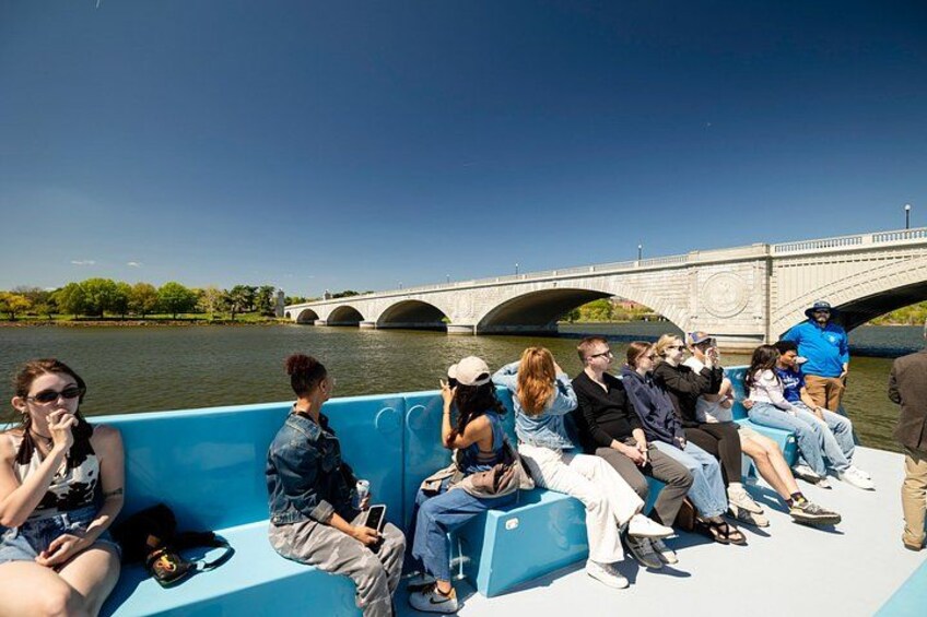 Un groupe de personnes se trouve sur un bateau, avec un pont en arrière-plan. 2