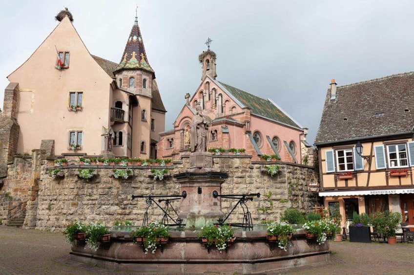 A historic building with a tower, a fountain with a bicycle, and a street with a restaurant. 2
