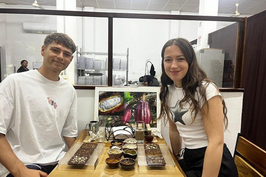 Deux personnes sont assises à une table, devant divers plats et une image représentant un fruit. 5