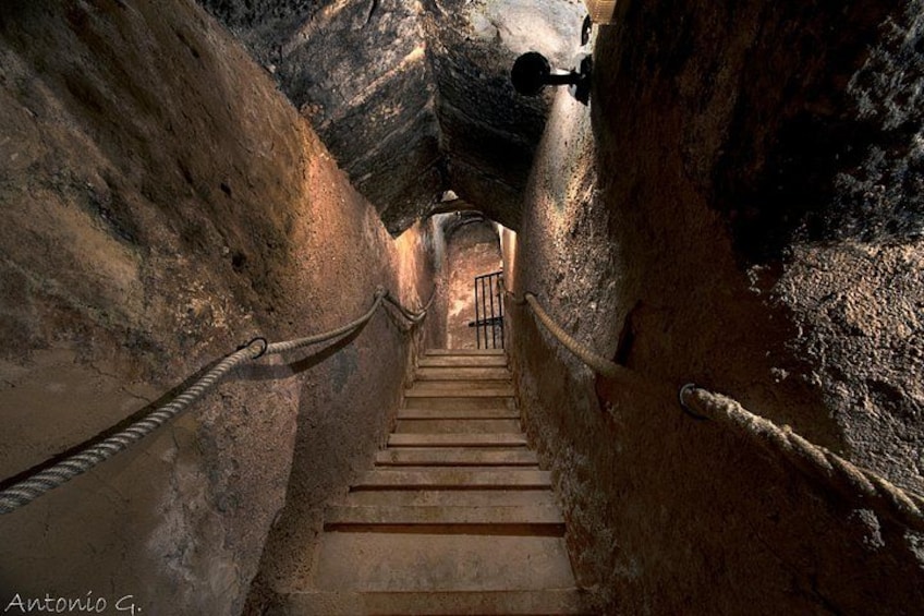 Una estrecha escalera de piedra que asciende dentro de una cueva. 2