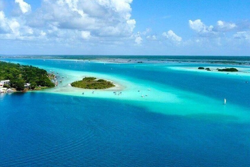 A turquoise sea with a small island surrounded by clear waters. 5