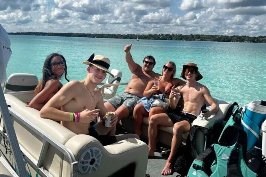 A group of people on a boat with a clear blue sea and a distant shoreline in the background. 4