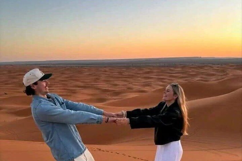 Two people holding hands in a desert landscape. 5