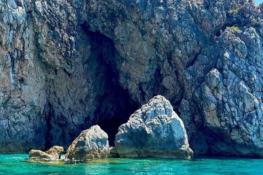 A rocky coastline with clear turquoise water and large boulders. 3