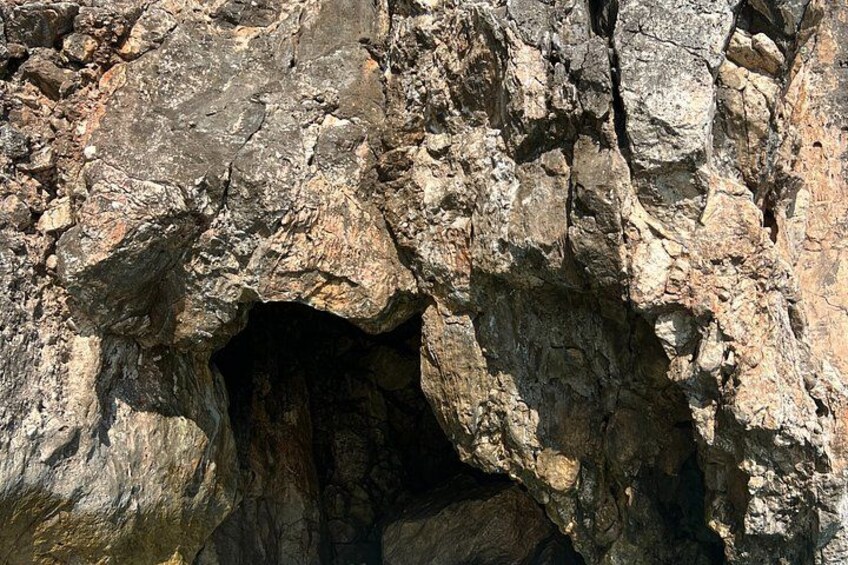 A rocky cliff with a cave entrance. 5