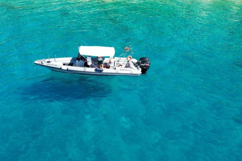 A small motorboat on clear turquoise water. 1
