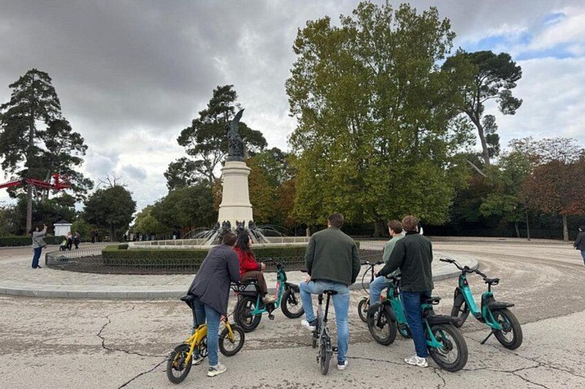 Een groep mensen op fietsen nabij een monument in een park. 5