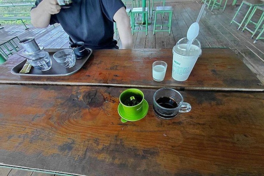 A wooden table with a tray containing a cup, a glass, and a small container. 4