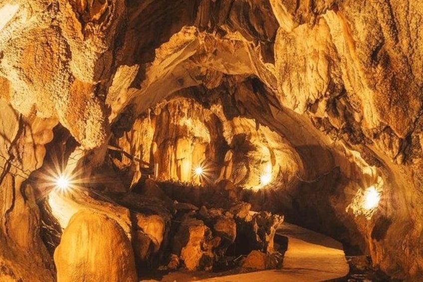 A cave with stalactites and stalagmites, illuminated by artificial lights. 2