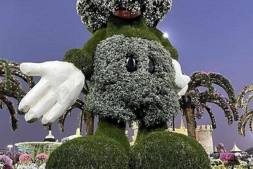 A large, green, moss-covered statue of a character with a white glove and a black button. 3