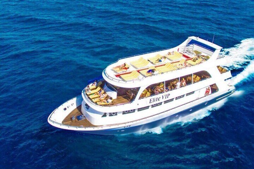 A large, multi-deck cruise ship with the name "Elite VIP" sailing on the ocean. 1
