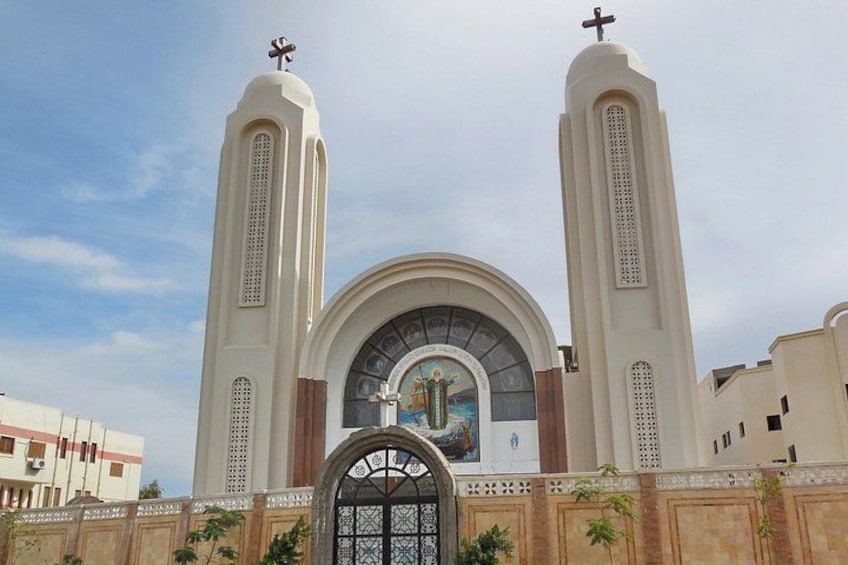 Una iglesia con dos torres, un amplio ventanal en arco y un portón decorativo. 3