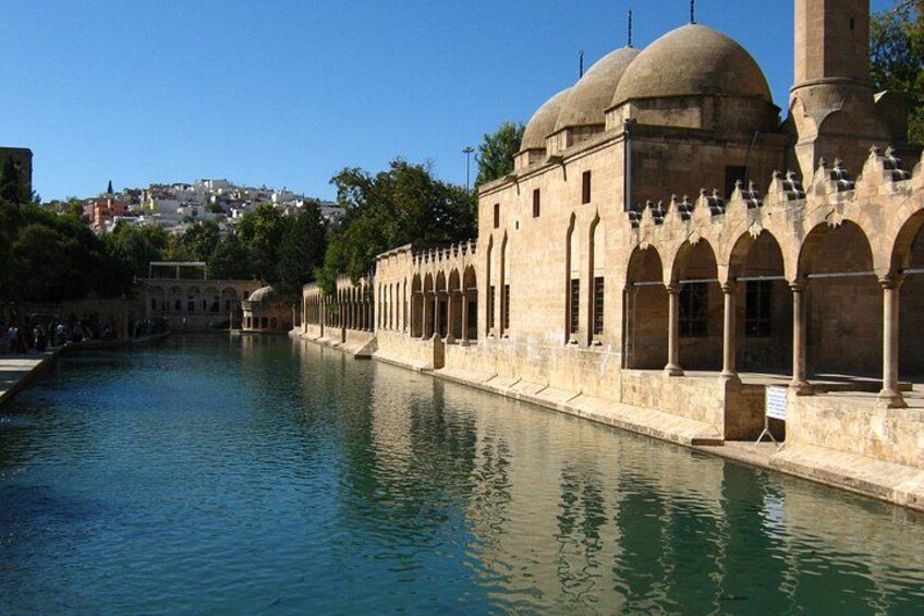 A historic building with arches and domes by a calm water body. 3