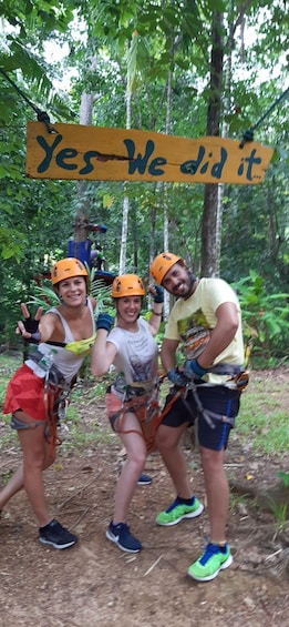 Three people in a forested area with a sign that says "Yes, We did it". 2