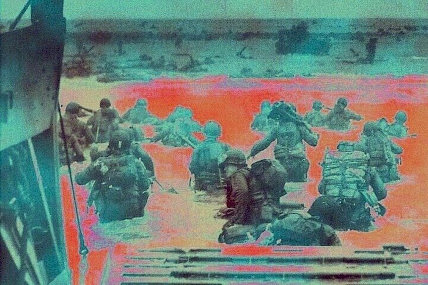 Soldiers disembarking from a landing craft onto a beach. 1