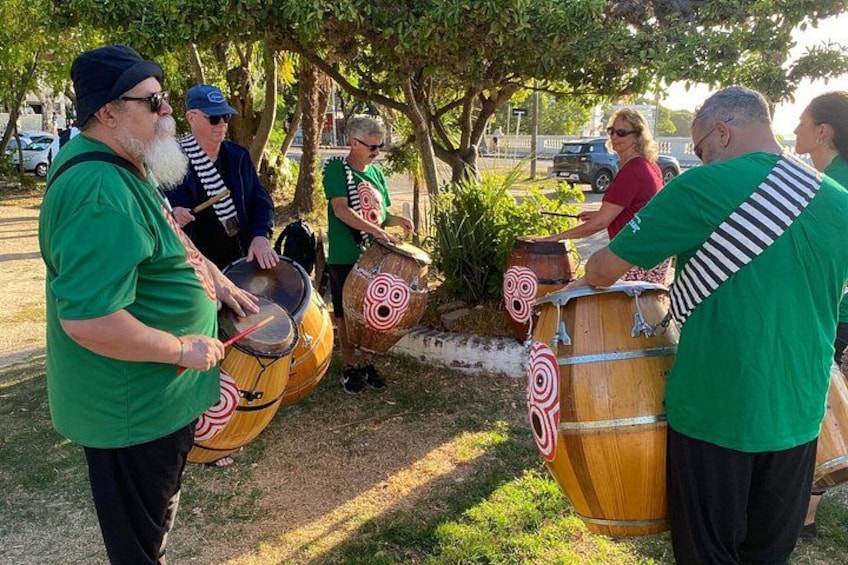 Un groupe de personnes jouant de la batterie en plein air. 2
