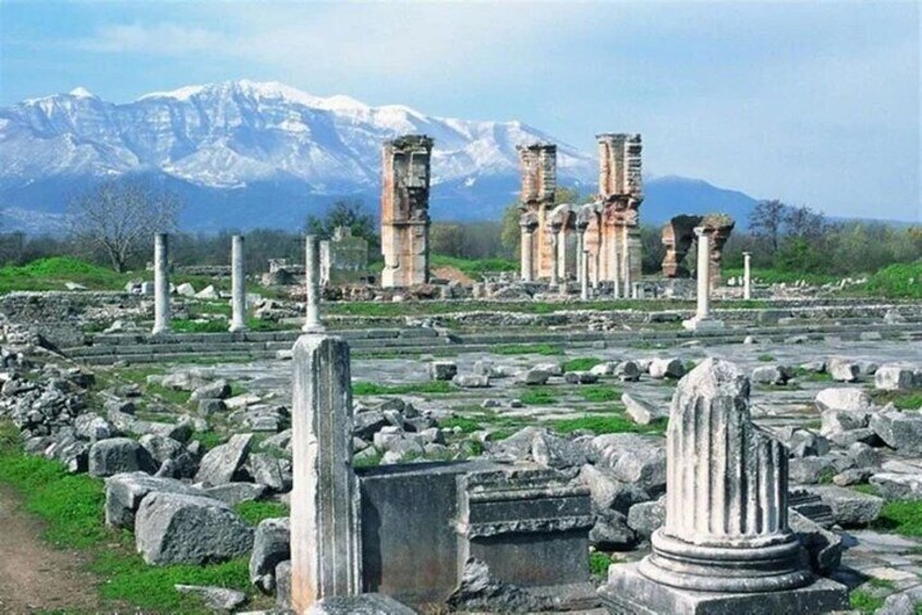 Ancient ruins with columns and a mountainous backdrop. 1