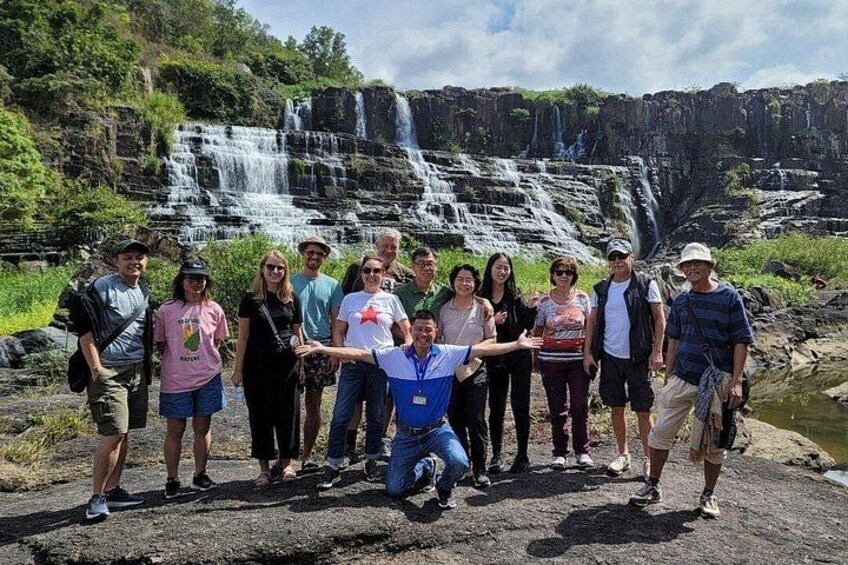 A group of people standing in front of a waterfall. 4