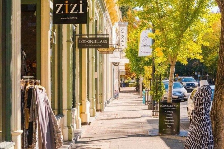 Een straat met winkelgevels, waaronder 'zizi' en 'Lookin' Glass'. 4