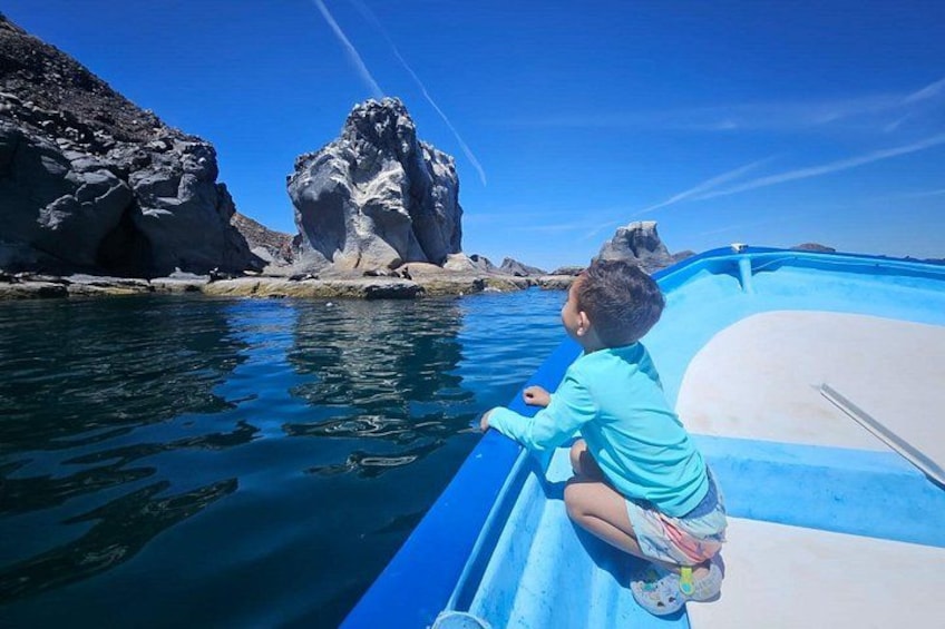 Un niño en un bote cerca de acantilados rocosos. 3