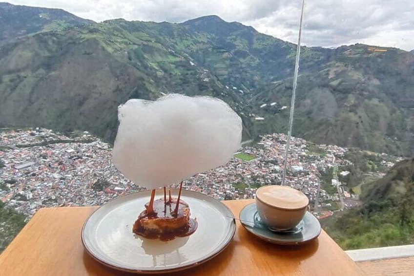 Un dessert agrémenté de barbe à papa, servi sur une assiette, une tasse de café et, en arrière-plan, une vue imprenable sur les montagnes. 5