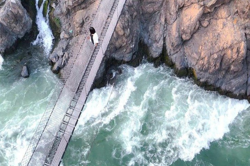 Iemand staat op een brug boven een snelstromende rivier. 3