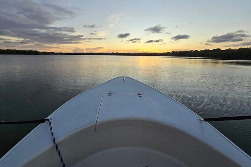 Un bateau sur une eau calme, au coucher du soleil. 1