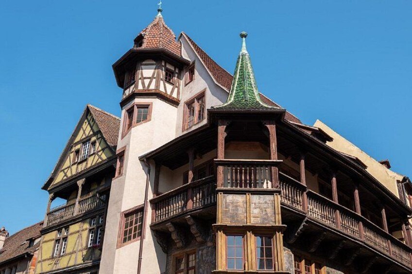 Ein traditionelles Fachwerkhäuschen mit einer grünen Spitze und einem Turm. 2