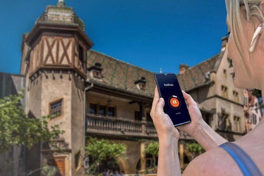 A person holding a smartphone with a music app interface. 4