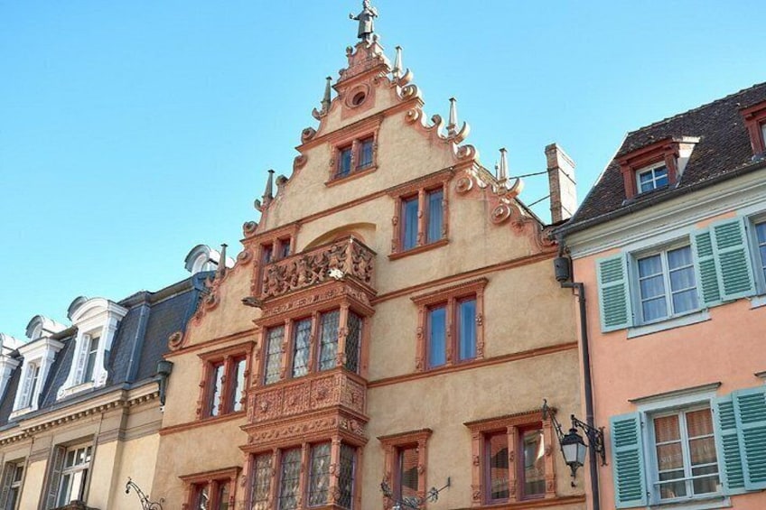 A historic building with ornate architectural details, including a gabled roof and decorative window frames. 2
