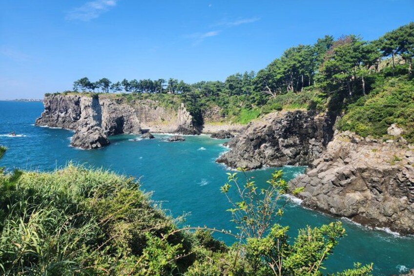 A coastal landscape with rocky cliffs and lush greenery. 3
