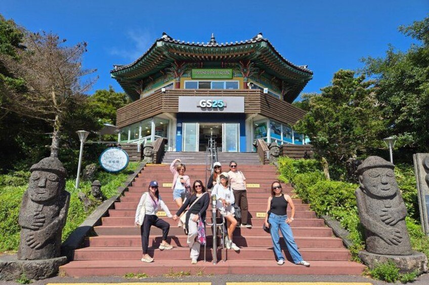 A traditional Korean building with a sign reading 'GSSG' at the top of a staircase surrounded by stone statues. 2