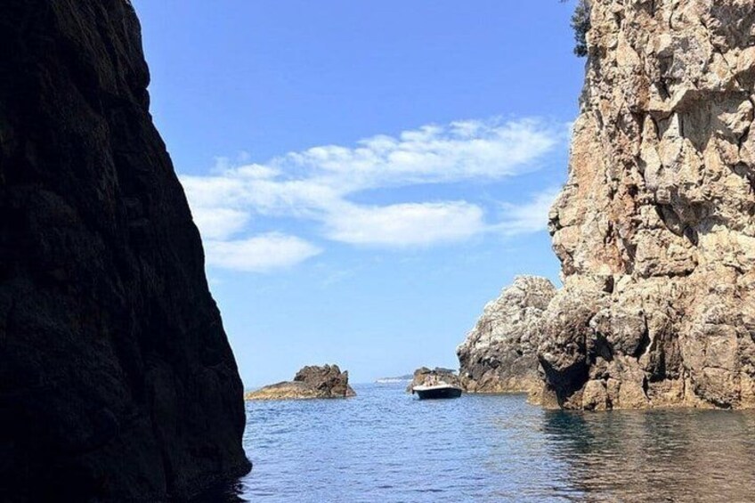 Una costa rocosa con un bote en el agua. 2