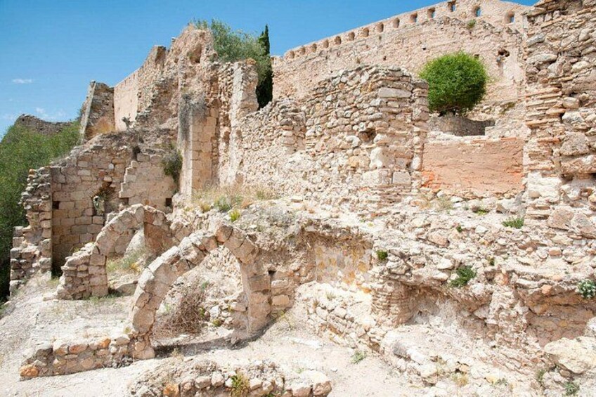 Ancient stone ruins with arches and a fortified wall. 5