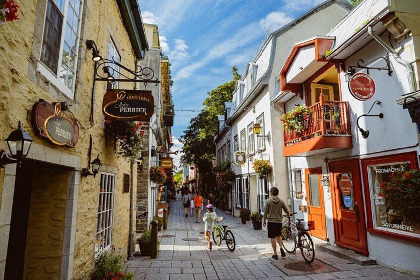 A narrow street with buildings, bicycles, and pedestrians. 4