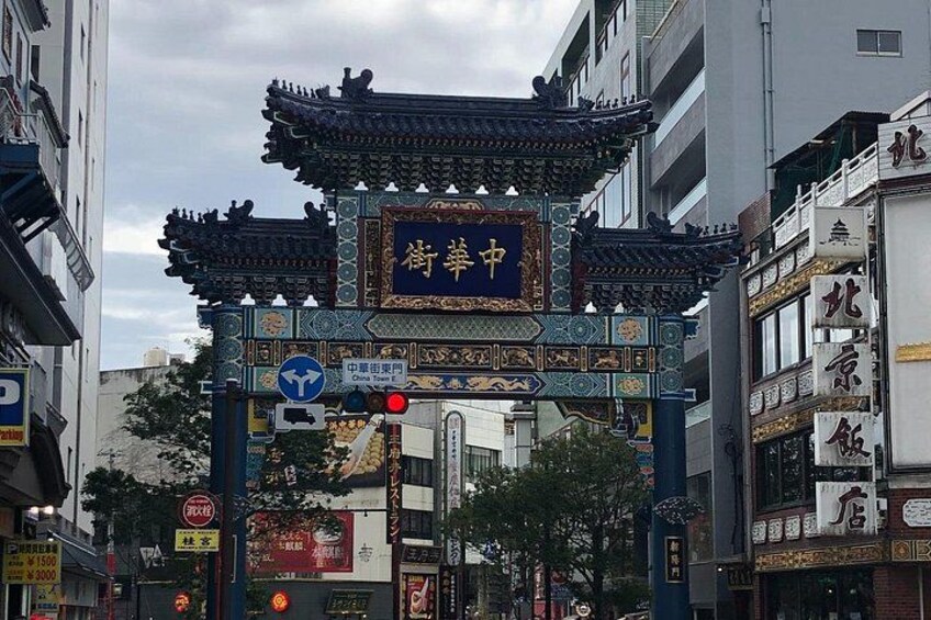 A traditional Chinese gate with intricate designs and a sign above it. 5