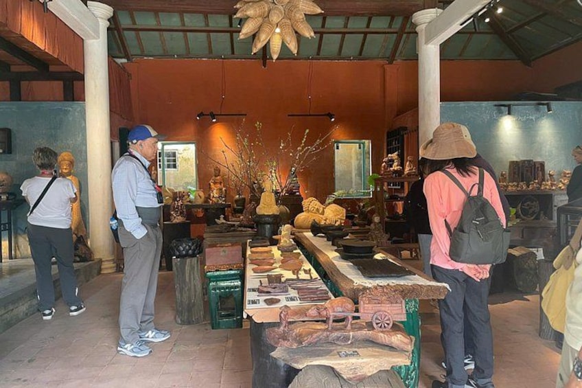 A temple interior with statues, offerings, and visitors. 2