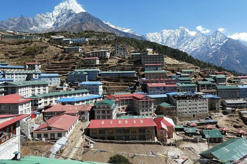 A mountainous village with buildings, a snow-capped peak, and terraced fields. 3
