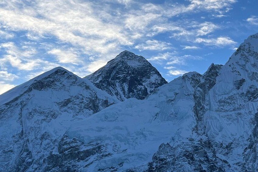 Snow-covered mountain peaks under a partly cloudy sky. 4