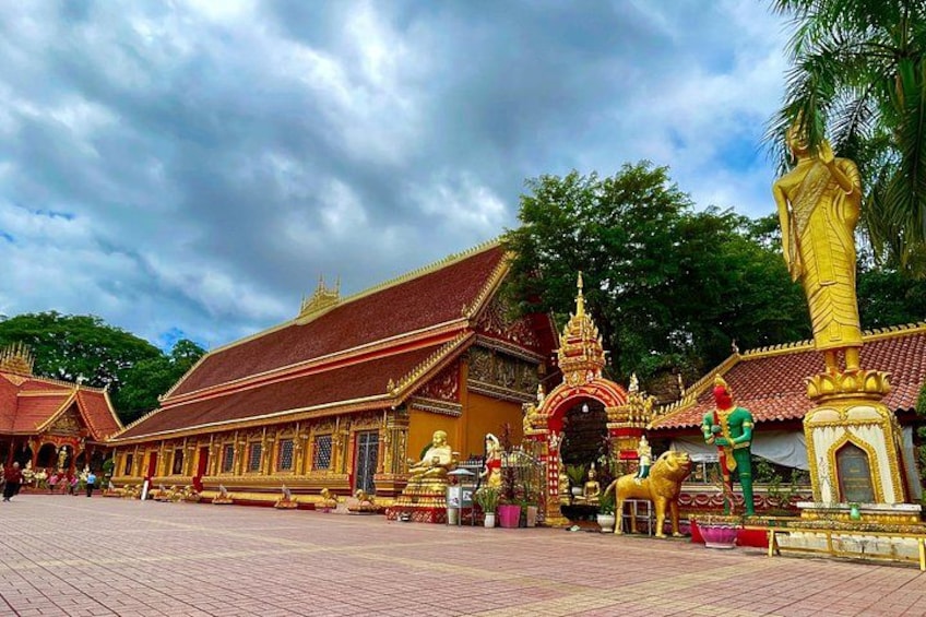 A traditional temple with ornate architecture, a large golden statue, and a well-maintained courtyard. 3