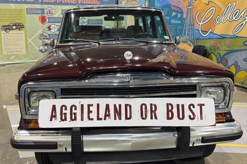 A vintage car with a sign that reads 'AGGIELAND OR BUST.' 2